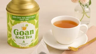 SAN-CHA「Goan Iced Tea」の美しい缶と、ホットティーのカップが映る温かみのある写真。