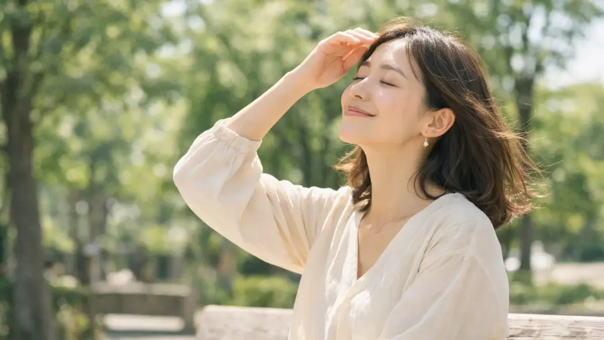 やわらかな日差しの中で目を閉じて心地よさを感じている女性